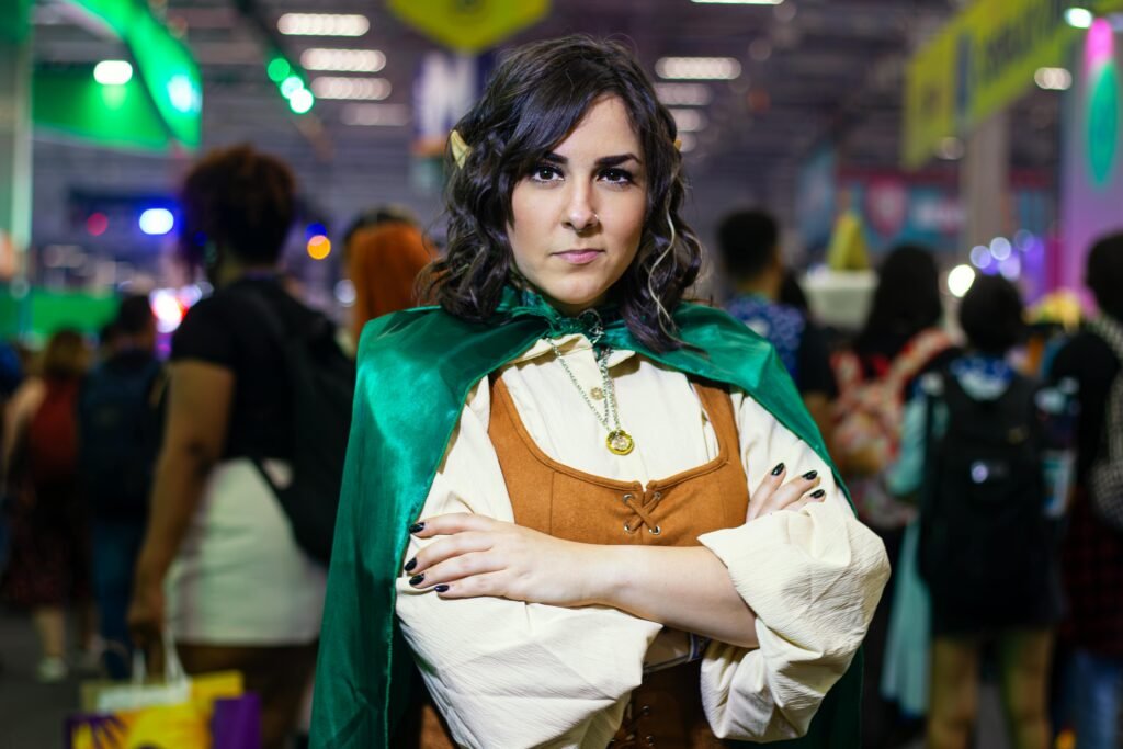 A young woman in cosplay attire posing confidently at a bustling fan event. By Danilo Duarte